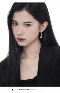 Model wearing large irregular wavy silver earrings in a minimalist fashion style