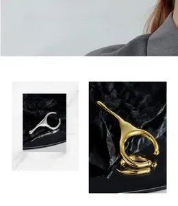 Detail of irregular waterdrop ear cuffs in silver and gold minimalist finish
