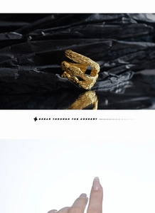 Detailed view of layered hollow ring with gold lava texture on black and white background