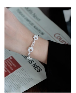 Primer plano de pulsera de plata esterlina S925 con flores de textura de lava irregular