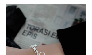 Detalle de una pulsera de cadena de plata de ley S925 con colgante de oso en la muñeca