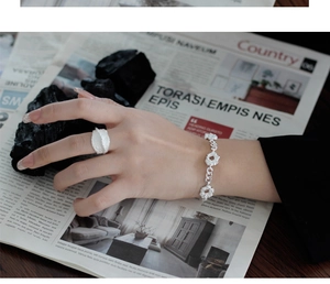 Detalle del conjunto de pulsera y anillo de plata S925 con textura de lava única