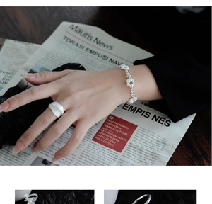 Detalle de anillo de plata S925 con textura y conjunto de pulsera de flores