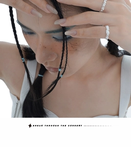 Macro detail of irregular silver rings with rock texture worn by a model