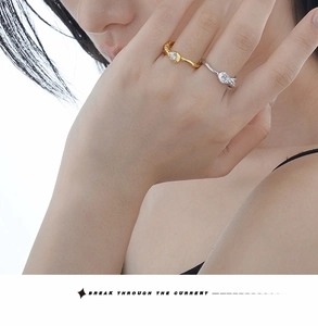 Détail des bagues texturées dorées et argentées avec zircons portées par un mannequin chic