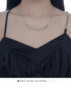 Close-up of S925 sterling silver necklace with irregular wavy liquid metal pendant on a model
