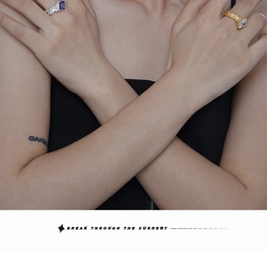 Detailed view of silver and gold rings with rectangular stones and lava-like textures