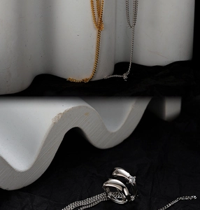 Macro shot of silver ring with zircon stone and tassel chain on minimalist stone props