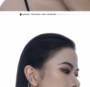 Detail of silver double-layered ear cuff with long metallic tassels on model ear