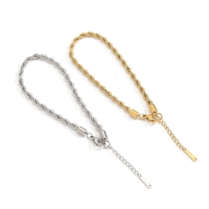Close-up of gold and silver rope chain anklets with lobster clasps and extension tags