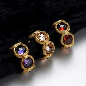 Three gold-plated S925 silver rings with zircon inlay and lava texture on dual tone backdrop