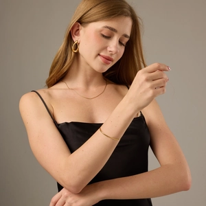 Golden irregular teardrop earrings, necklace and bracelet set on a female model