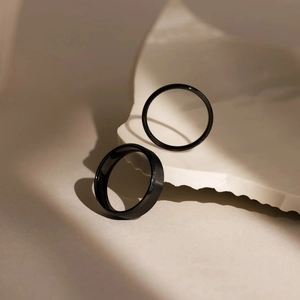 Minimalist black stainless steel ring set with matte and polished bands on stone