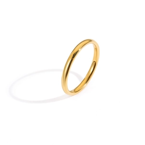 Macro shot of polished gold-finished stainless steel minimalist ring on white backdrop