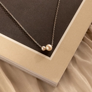 Élégant pendentif double perle d'eau douce sur chaîne dorée fine avec fond de soie douce