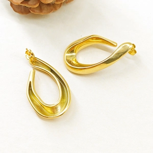 Détails des boucles d'oreilles dorées en forme de larmes torsadées avec fini brillant