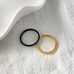 Minimalist stackable rings set featuring smooth black and gold finish on fabric background