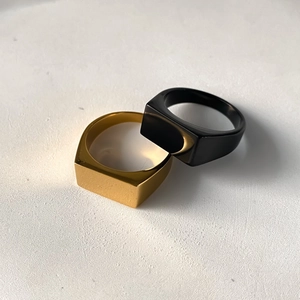 Macro shot of minimalist gold and black stainless steel rectangular signet rings
