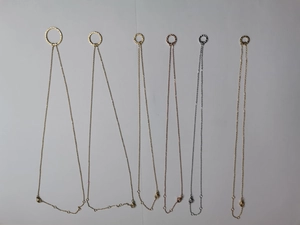 Detail of metal necklaces with hammered texture pendants in gold, silver, and rose gold finishes