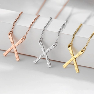 Three minimalist stainless steel X-shaped pendant necklaces with hammered texture finish