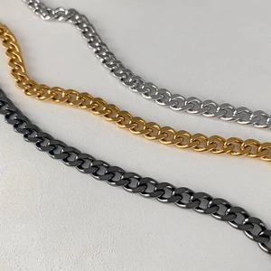 Tre catene a maglia cubana in oro argento e acciaio nero viste dall'alto in diagonale