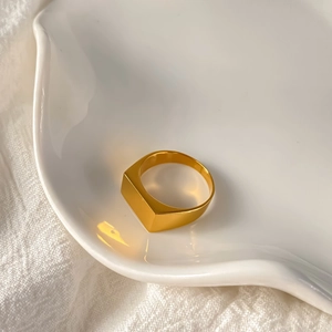 Minimalist gold rectangular signet ring in stainless steel with polished finish on white tray