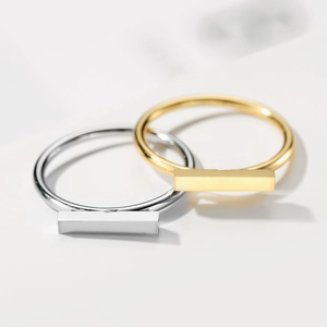 Macro shot of minimalist gold and silver titanium steel rings with rectangular bar detail