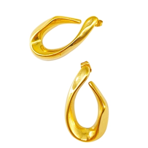 Détail de boucles d'oreilles dorées ovales torsadées avec finition miroir et design ajouré