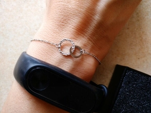 Detailed close-up of interlocking silver double ring bracelet with unique hammered texture