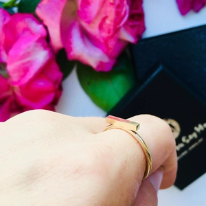 Detailed view of a gold titanium ring featuring a polished rectangular bar on a thin band