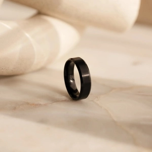 Dettaglio di un anello in acciaio inossidabile nero opaco su marmo elegante
