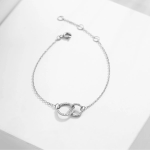 Detail of interlocking silver rings showing hammered texture and polished mirror finish