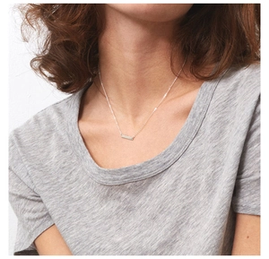 Minimalist silver bar necklace on female model neck with high polished finish