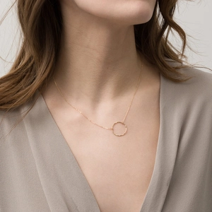 Minimalist hammered gold-plated round hollow pendant necklace worn by a female model