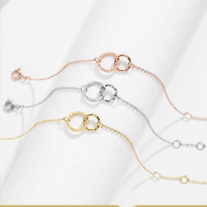 Detailed view of three hammered interlocking circle bracelets in gold, silver and rose gold