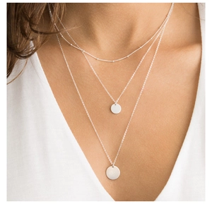 Detailed view of triple-layered stainless steel necklace with round silver pendant charms