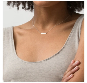 Silver bar necklace on model showing minimalist geometric pendant and delicate chain