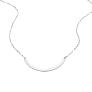 Dettaglio macro del ciondolo curvo lucido in argento su una catena sottile minimalista