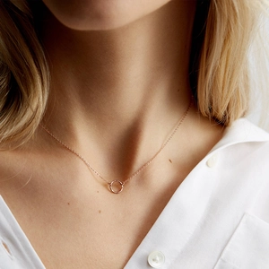 Minimalist rose gold necklace with a delicate round pendant on a female model neck
