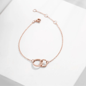 Detail view of double interlocking rings with hammered texture in rose gold finish