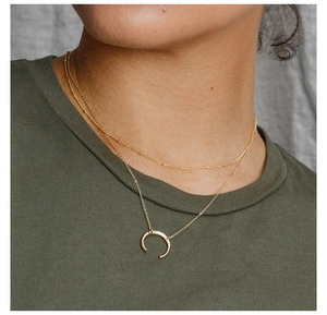 Close-up of double layer gold stainless steel necklace with crescent moon pendant