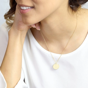 Collier minimaliste en acier inoxydable doré avec pendentif rond poli sur modèle