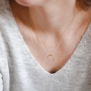 Minimalist hammer textured crescent moon pendant gold necklace on a grey sweater