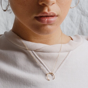 Elegant gold crescent moon pendant necklace on a minimalist snake chain worn by a model