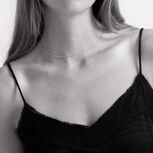 Minimalist stainless steel rose gold bead chain necklace shown on a model neck