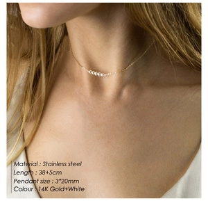 Close-up of model wearing 14K gold plated stainless steel necklace with five white pearls