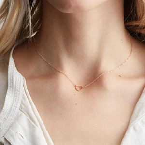 Elegant rose gold hollow circular pendant necklace on model's neckline for minimalist style