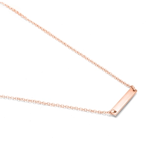 Macro shot of minimalist rose gold rectangular bar pendant necklace with thin cross chain