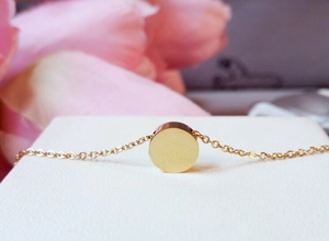Close-up of minimalist golden round pendant necklace with a polished metallic finish