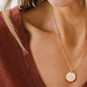 Vue détaillée du collier pendentif cercle doré minimaliste porté par un mannequin